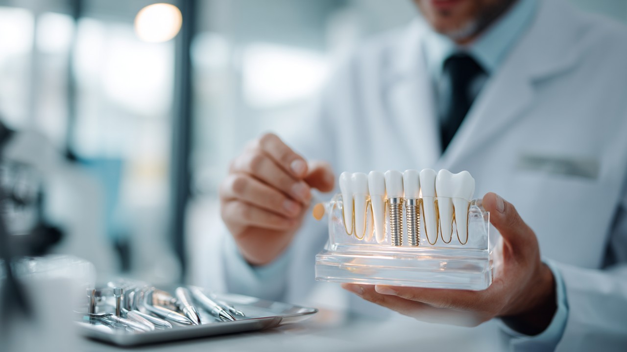 Modern diş kliniğinde, profesyonel diş hekimi gelişmiş implant modellerini inceliyor, yüksek teknoloji diş aletleri ve implant malzemeleri tepside.