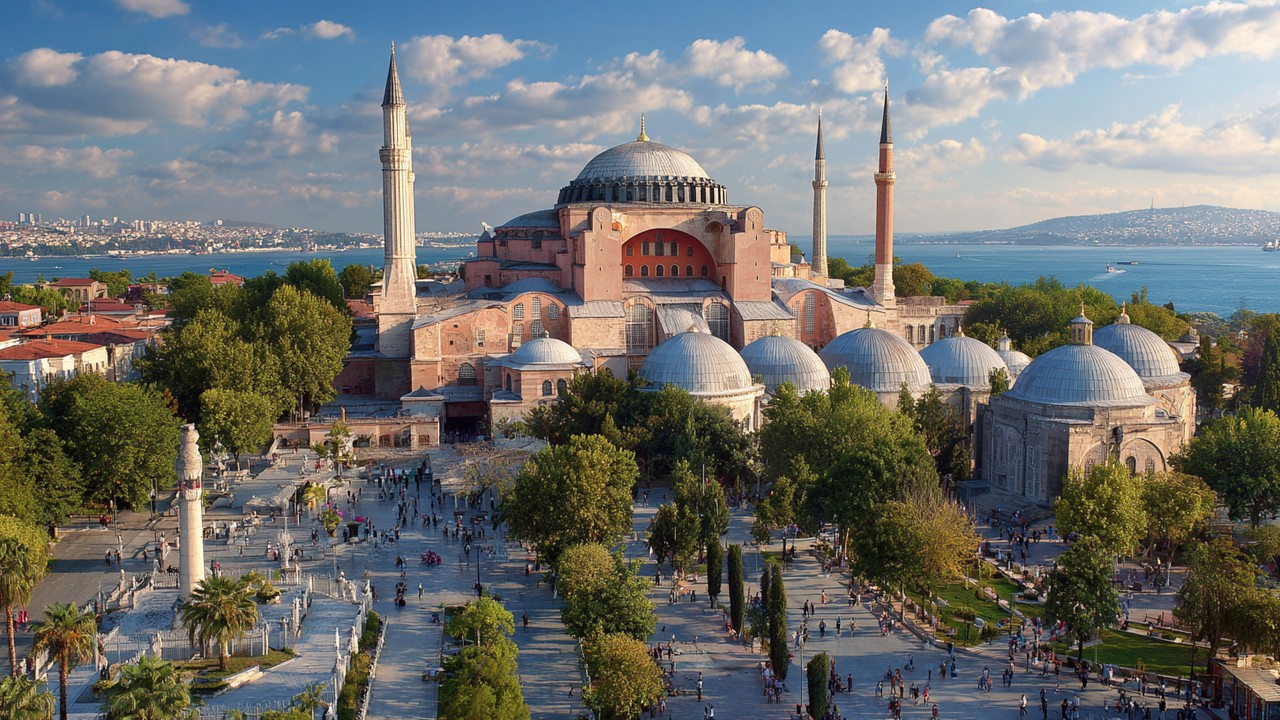 Weitwinkelaufnahme der historischen Halbinsel Istanbuls mit Hagia Sophia, Topkapi-Palast und Sultan-Ahmed-Moschee bei schönem Himmel, voller Touristen.