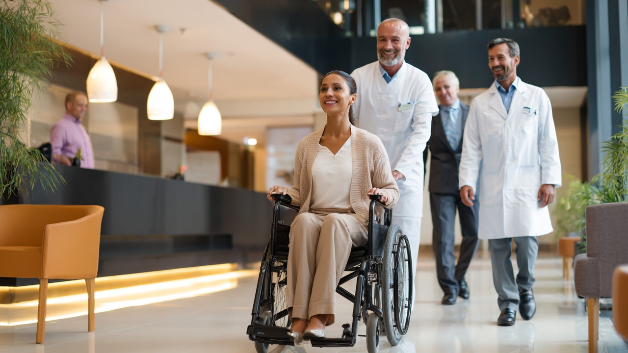 Moderne Gesundheits-Tourismus-Hotel-Lobby mit medizinischem Personal, das einen Rollstuhlfahrer betreut, barrierefreies Design, einladendes Umfeld