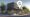 Realistic image of a healthcare clinic storefront with signage and Google Maps location marker in a vibrant urban neighborhood during daytime.