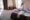 Joyful female is having phone conversation in her hotel room