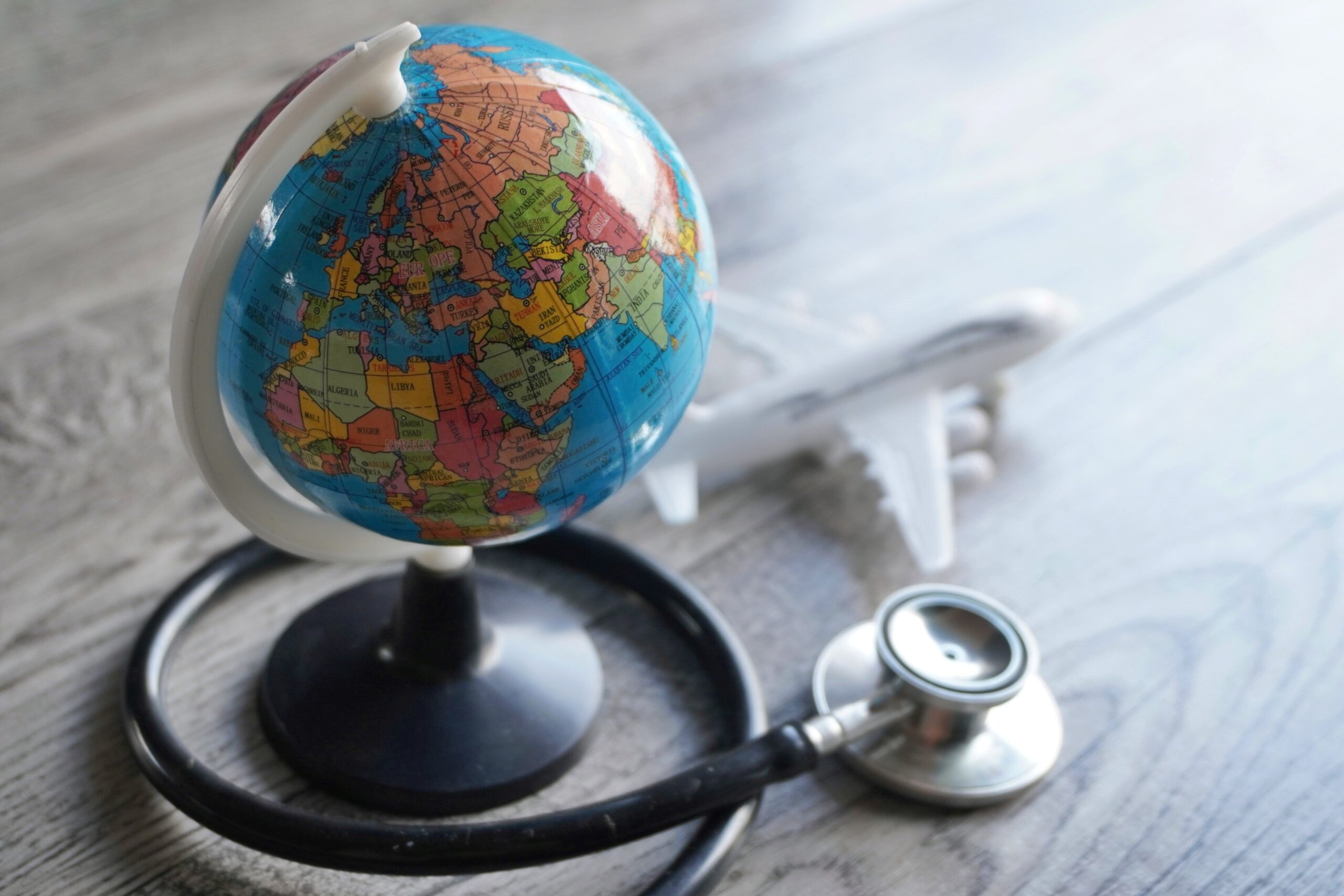 Selective focus image of globe, toy plane and stethoscope.