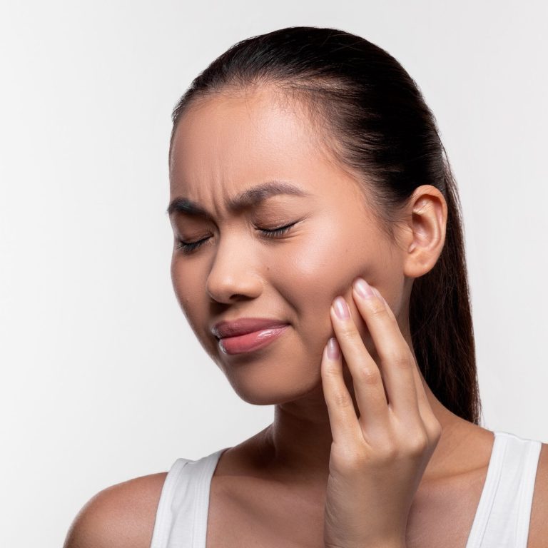 Sad korean millennial lady with closed eyes experiencing strong wisdom tooth pain, touching her cheek, white studio background, panorama with copy space, closeup photo. Dental health concept