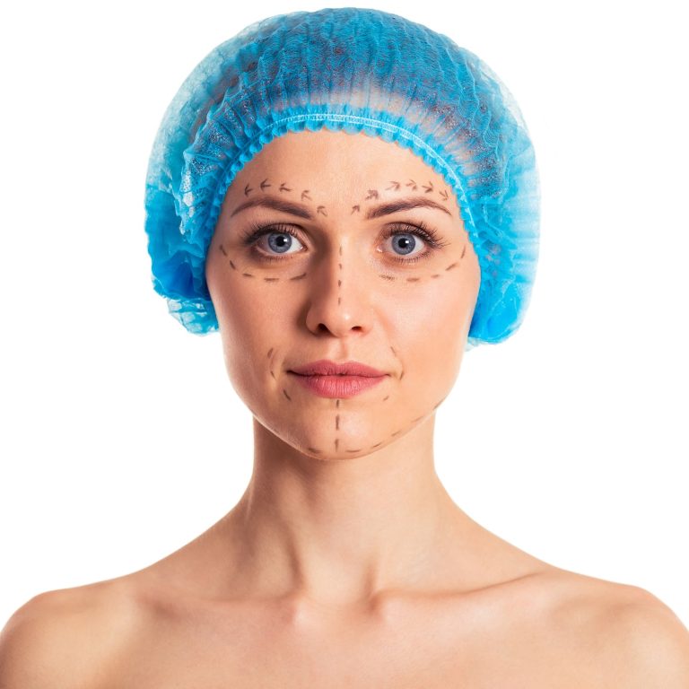 Beautiful woman in medical headwear with sketches on face is looking at camera, isolated on a white background